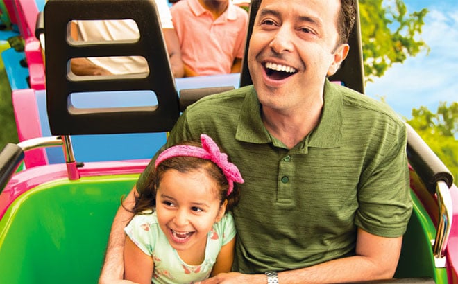 Dad riding a roller coaster with his daughter